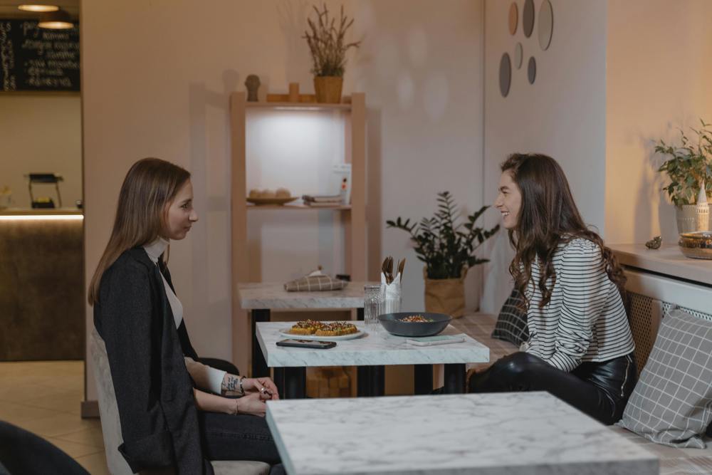Two friends having a conversation at a cafe